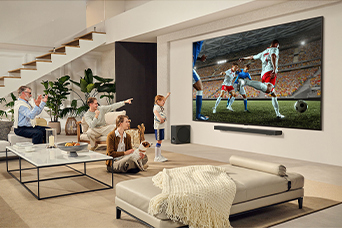 A family is gathered around their LG Ultra Big TV watching an exciting soccer match on the huge screen.