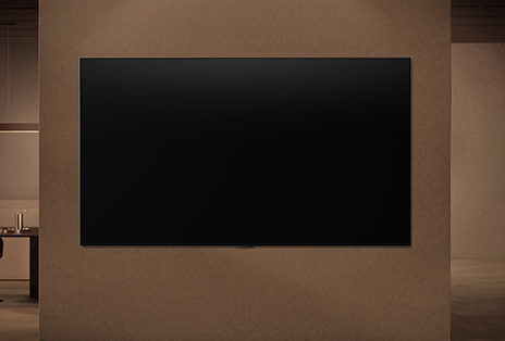 A wall-mounted LG TV with its display switched off showing how the TV's motion sensors can intelligently adjust depending on the detected motion nearby.