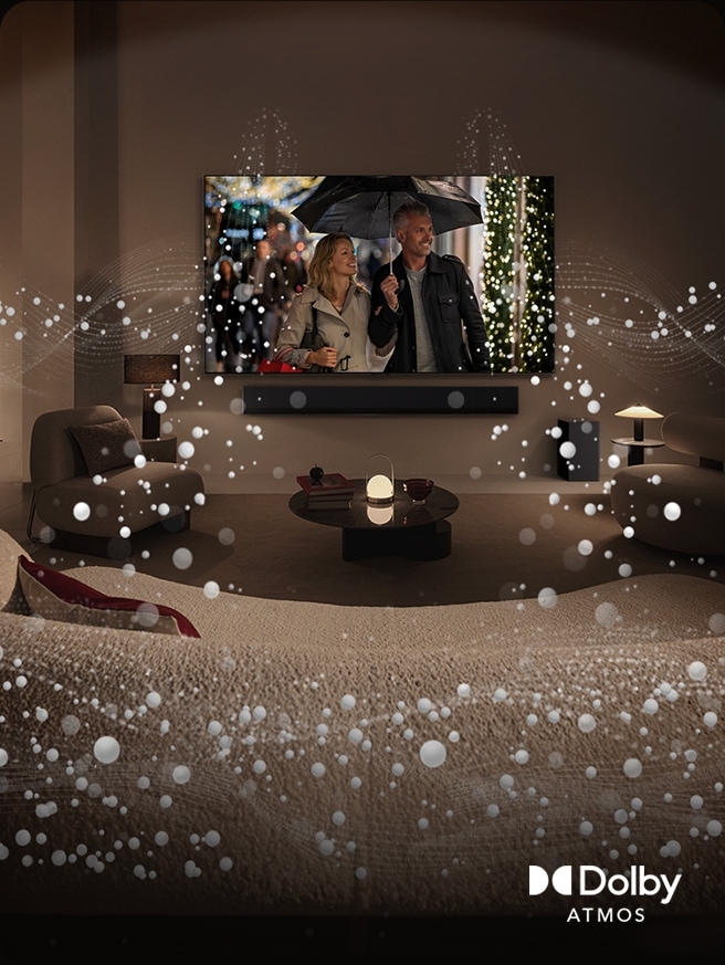 A cozy, dimly lit living space, LG OLED TV displaying a couple is using an umbrella, and bright circle graphics surround the room. Dolby Atoms logo in the bottom left corner.