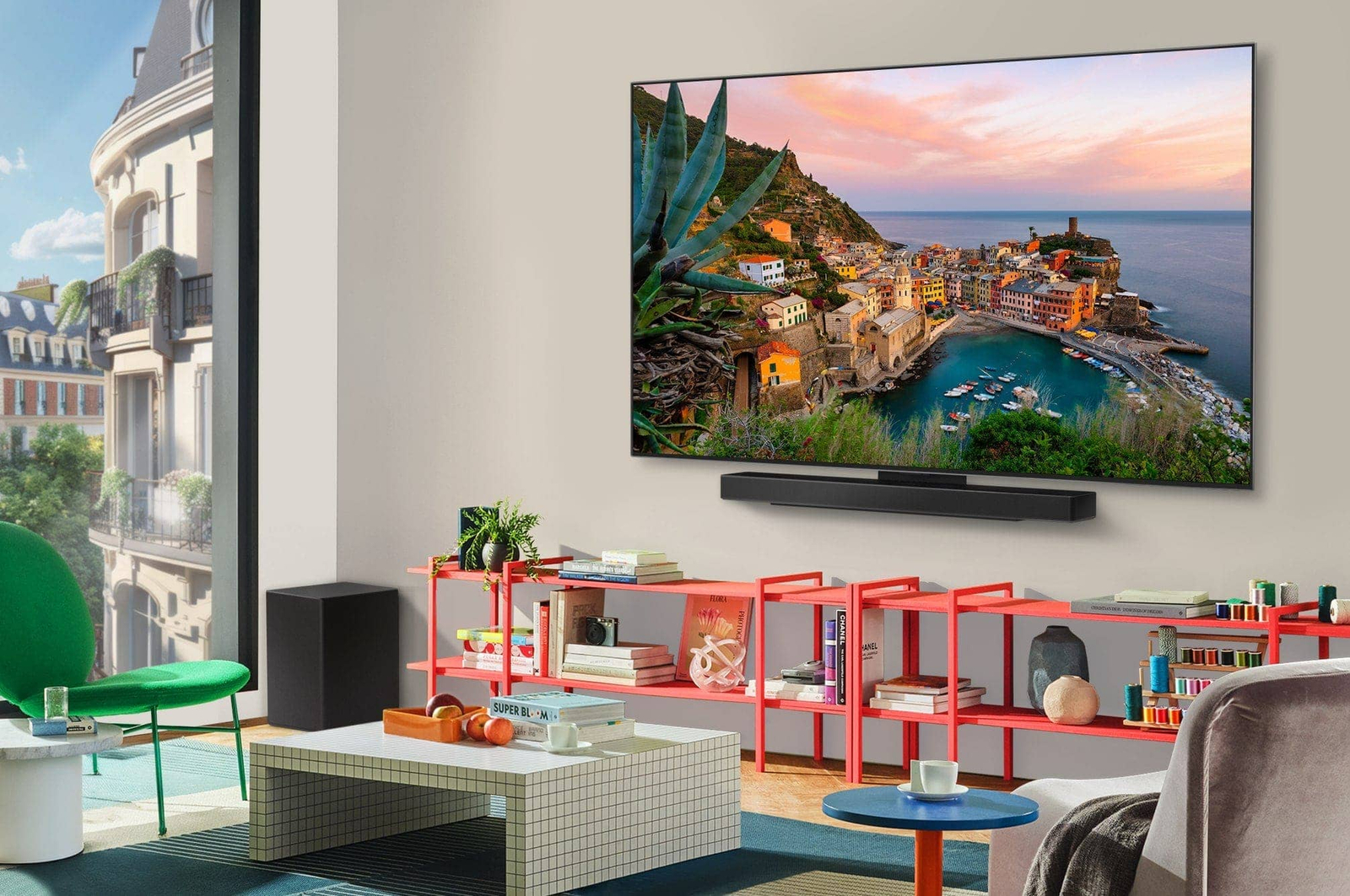 Wide view of a stylish and colorful living room. LG OLED evo AI C5 4K Smart TV is mounted on the wall with an LG Soundbar underneath it. The TV's design blends well with the space. On the TV screen is a colorful artwork.