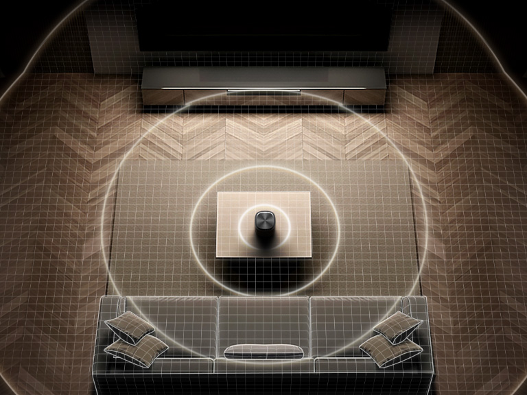 Top-down view of a living room where circular sound waves spreading evenly between the speaker and soundbar, illustrating Room Calibration