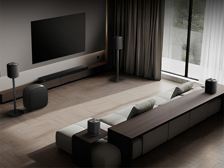 1) LG Sound Suite placed in a living room, demonstrating flexible speaker placement for an immersive home sound system 2) LG Sound Suite with Dolby Atmos FlexConnect technology detects each speaker’s location to optimize surround sound systems 3) Close-up of the LG Sound Suite W7 woofer with its driver showing deep bass performance down to 29.5 Hz