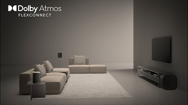LG OLED evo AI C5 Sound Suite with DAFC (Dolby Atmos FlexConnect) shows a wide room where the TV and wireless speakers are freely positioned, conveying immersive Dolby Atmos audio optimized for flexible speaker placement.