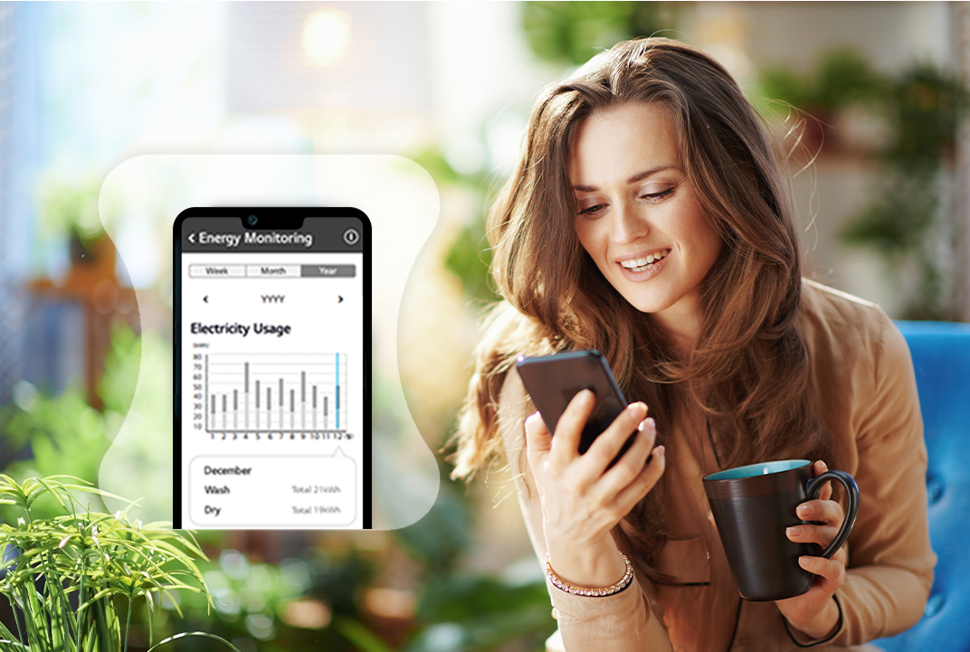 Woman holding a phone beside an LG laundry energy usage graph illustrates energy monitoring through the ThinQ app.