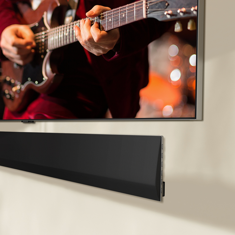 An angled view of the bottom of an LG OLED TV and LG Soundbar.