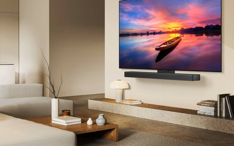 LG OLED TV with soundbar displaying a vivid sunset. Offers great picture quality and sound, ideal for gaming and cinematic experiences.