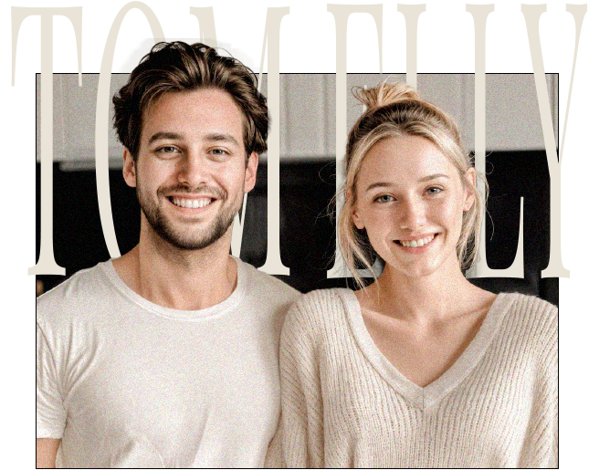 A smiling couple, a man and a woman, are hugging and looking straight ahead.
