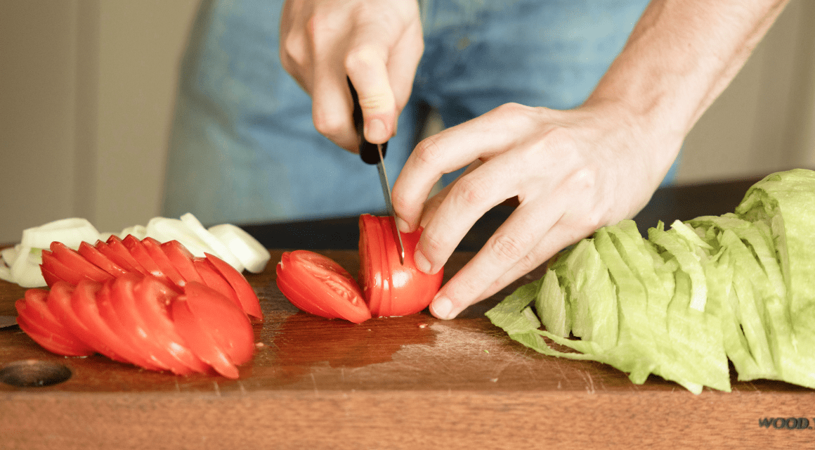A person is preparing ingredients for food to be eaten at a Football Party.