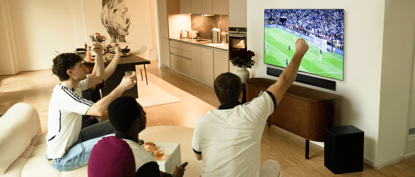 Janis Danner cheers as she sits on the sofa with her friends and watches a football game on her LG OLED G4 TV.
