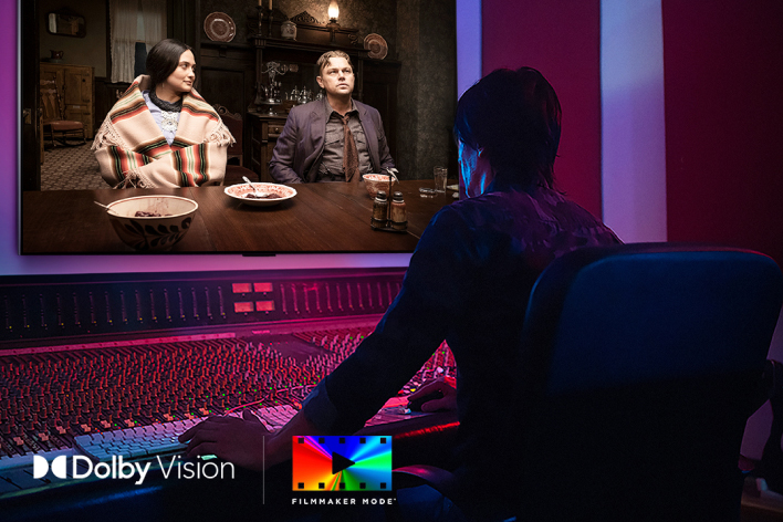 A director in front of a control panel editing the movie "Killers of the Flower Moon" on an LG QNED TV. In the bottom left, the Dolby Vision logo and FILMMAKER MODE logo.