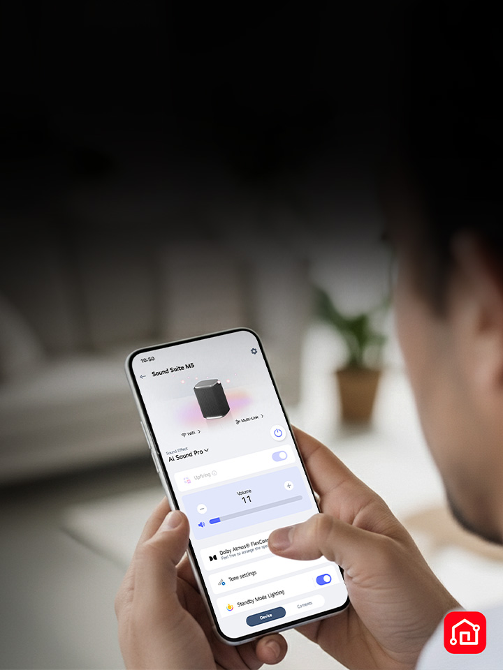A person holding a smartphone with the LG ThinQ app open, showing easy control of the LG Sound Suite