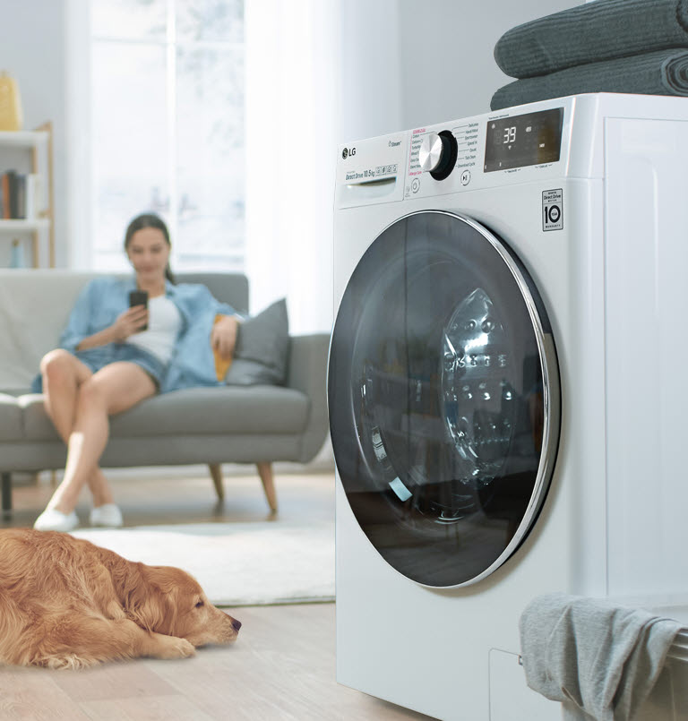 A video shows a white washer sitting at an angle in a room with a basket full of linen next to it. Six icons representing the different motions of the washer for optimal washing fade onto the screen. The LG 6 Motion logo is at the upper right of the six icons.
