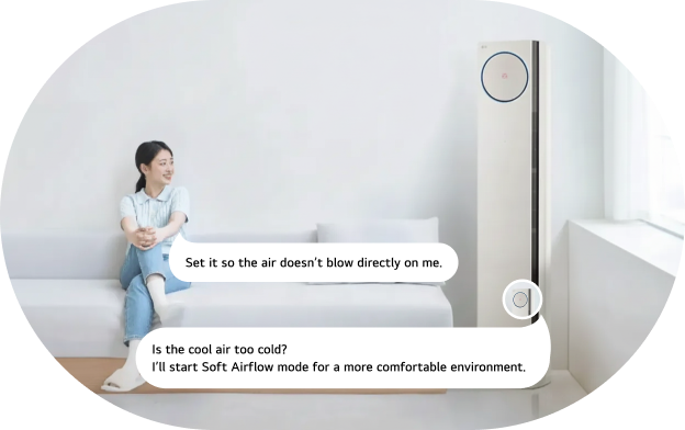 An image of the LG air conditioner AI voice command feature. A woman sits on a sofa looking at an LG standing air conditioner and issuing a voice command, with command and response speech bubbles displayed. Command: 'Keep the air from blowing on me.' Response: 'Is the cold air too chilly? Starting Soft Wind mode for a more comfortable environment.'