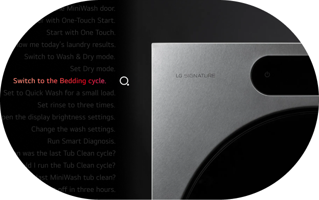 A dark-themed UI screen displaying a list of voice command examples for an LG SIGNATURE washing machine. The command "Switch to the Bedding cycle." is highlighted in red, indicating the currently selected or featured command. A search icon appears to the right of the highlighted command. The full list of visible commands reads: - Open the MiniWash door. - Start the washer with One-Touch Start. - Start with One Touch. - Show me today's laundry results. - Switch to Wash & Dry mode. - Set Dry mode. - Switch to the Bedding cycle. (highlighted) - Set to Quick Wash for a small load. - Set rinse to three times. - Open the display brightness settings. - Change the wash settings. - Run Smart Diagnosis. - When was the last Tub Clean cycle? - When should I run the Tub Clean cycle? - When was the last MiniWash tub clean? - Turn it off in three hours. - Schedule it to start in ten hours. (partially visible) On the right side of the image, the top portion of an LG SIGNATURE washing machine is visible, showing the brand logo and power button on a brushed metal surface.