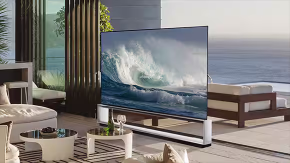 LG OLED Z2 is in a minimalist white room in front of a window that looks onto a forest of trees