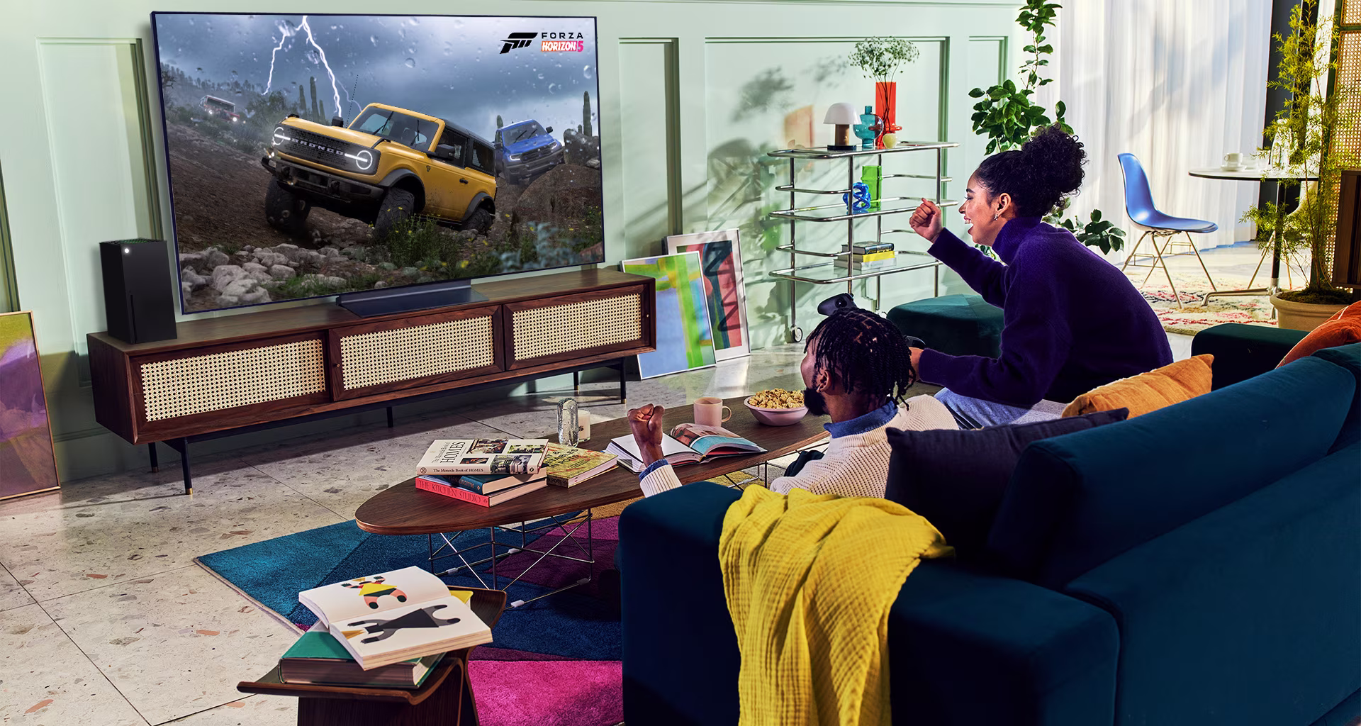 A person plays a racing game with an XBOX Series X|S controller on an LG OLED television