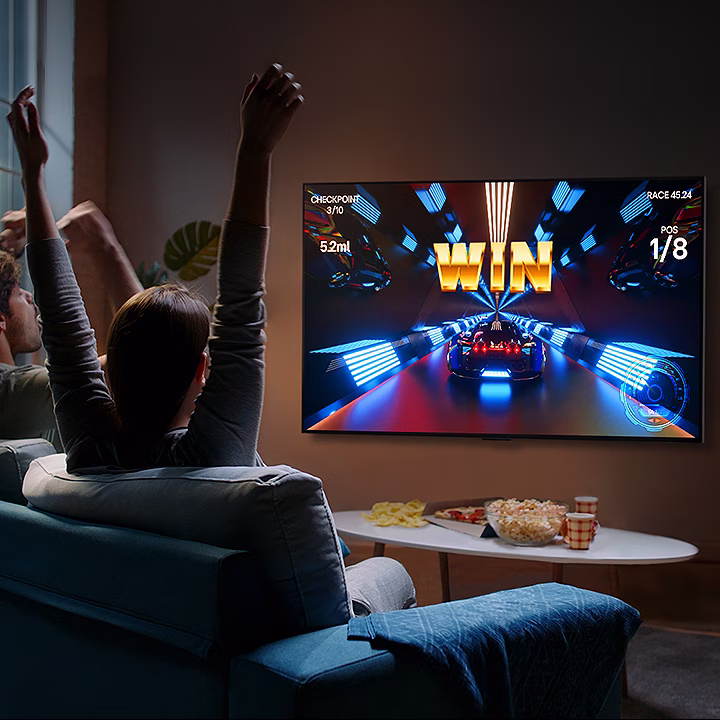 People play a game with a controller on the LG OLED television